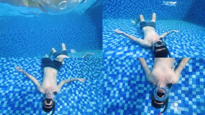 一个男人躺在游泳池底部制作泡泡环的水下场景。