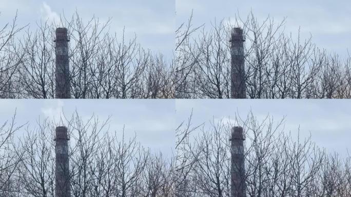 城市锅炉房冒烟的老倾斜烟囱。工业化和生态主题。