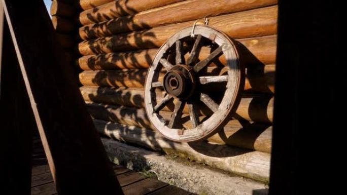 马车或马车上的古董木轮挂在原木墙上。