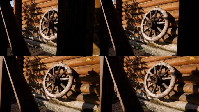 马车或马车上的古董木轮挂在原木墙上。