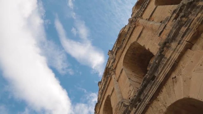 古代历史建筑建筑的一部分被隔离在蓝色阳光明媚的天空背景下，并在上面流着白云。