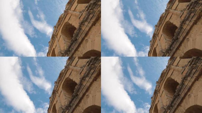 古代历史建筑建筑的一部分被隔离在蓝色阳光明媚的天空背景下，并在上面流着白云。
