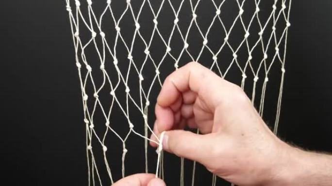 人的手用白色合成纤维，绳索，编织网，延时