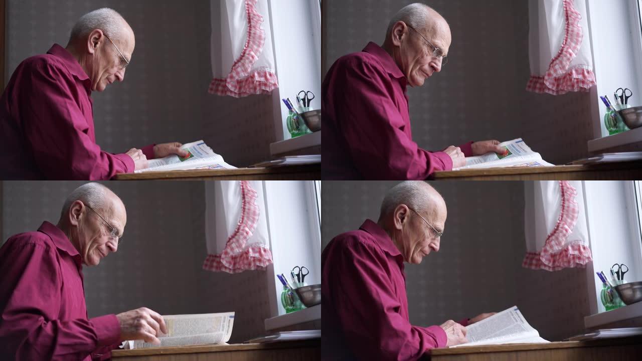 白发苍苍的老爷爷坐在桌边看报纸。