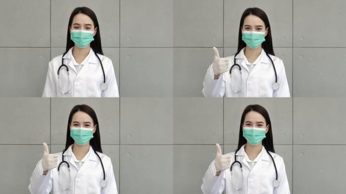 一位亚洲女医生或护士穿着制服，配有听诊器，戴着医用口罩，戴着手套，站着举起右手和拇指欣赏你。