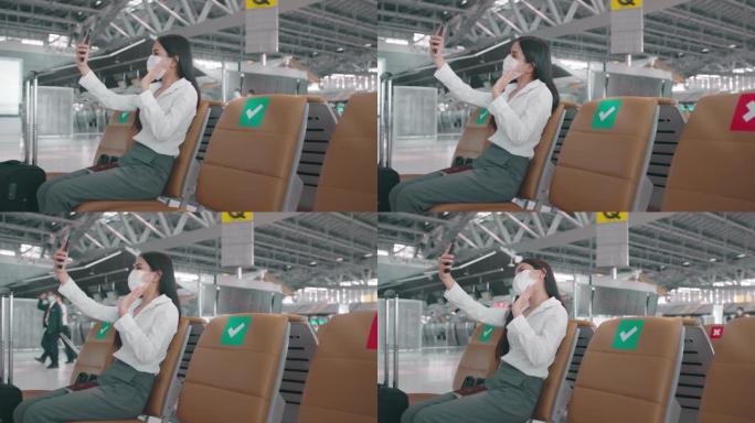 一名女商人在国际机场戴着防护口罩，视频通话给她的家人在新型冠状病毒肺炎大流行下旅行，安全旅行，社交距