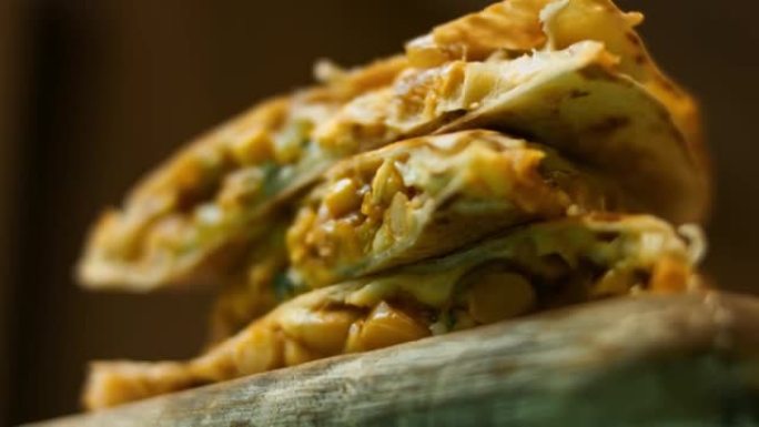 在木制切菜板上新鲜油炸的热蔬菜玉米饼。制作墨西哥玉米饼的过程。宏观视图
