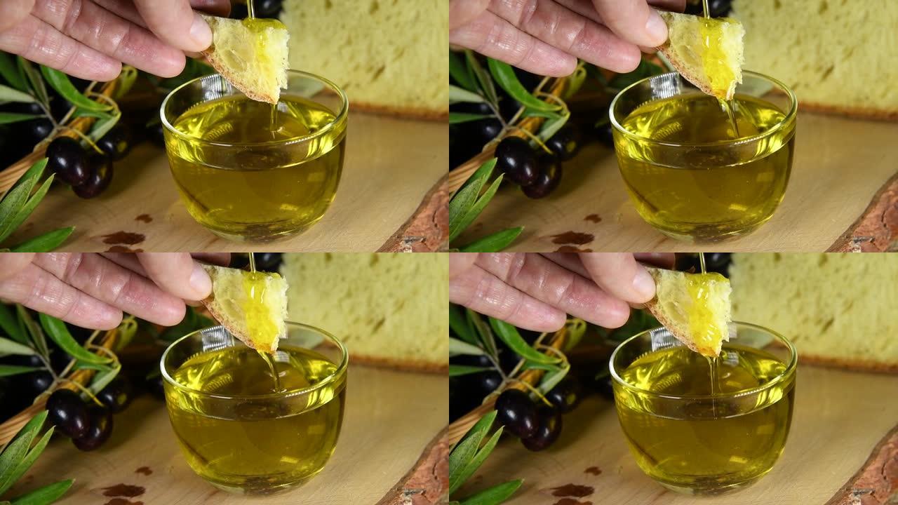 一只手将面包浸入冷榨橄榄油中