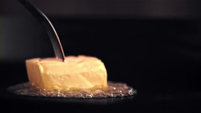 超级慢动作一块黄油在带有气泡的煎锅中融化。以1000 fps的高速相机拍摄。