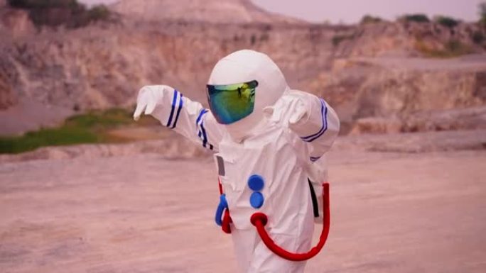 穿着太空服的女人在沙漠地区探索火星时，慢动作跳舞，表现出积极的情感和幸福，梦想着人类与水源，生命相遇