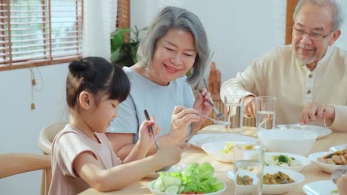 亚洲幸福大家庭一起花时间在餐桌上吃午饭。小女儿喜欢和父亲、母亲和祖父母一起吃饭。多代关系和房屋活动