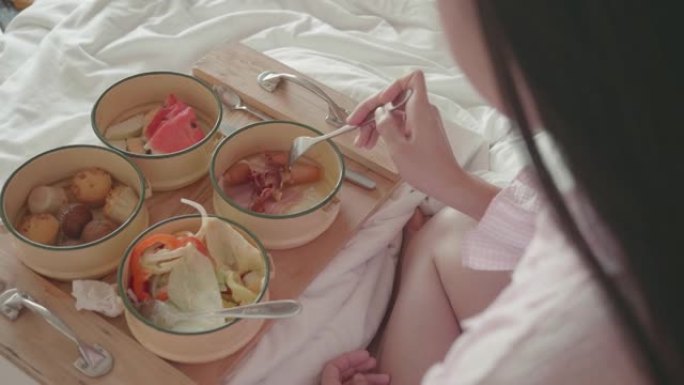 东南亚女人在床上吃早餐