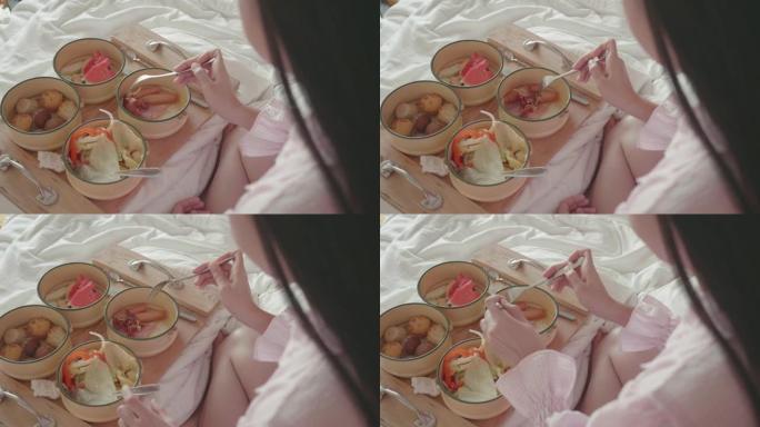 东南亚女人在床上吃早餐