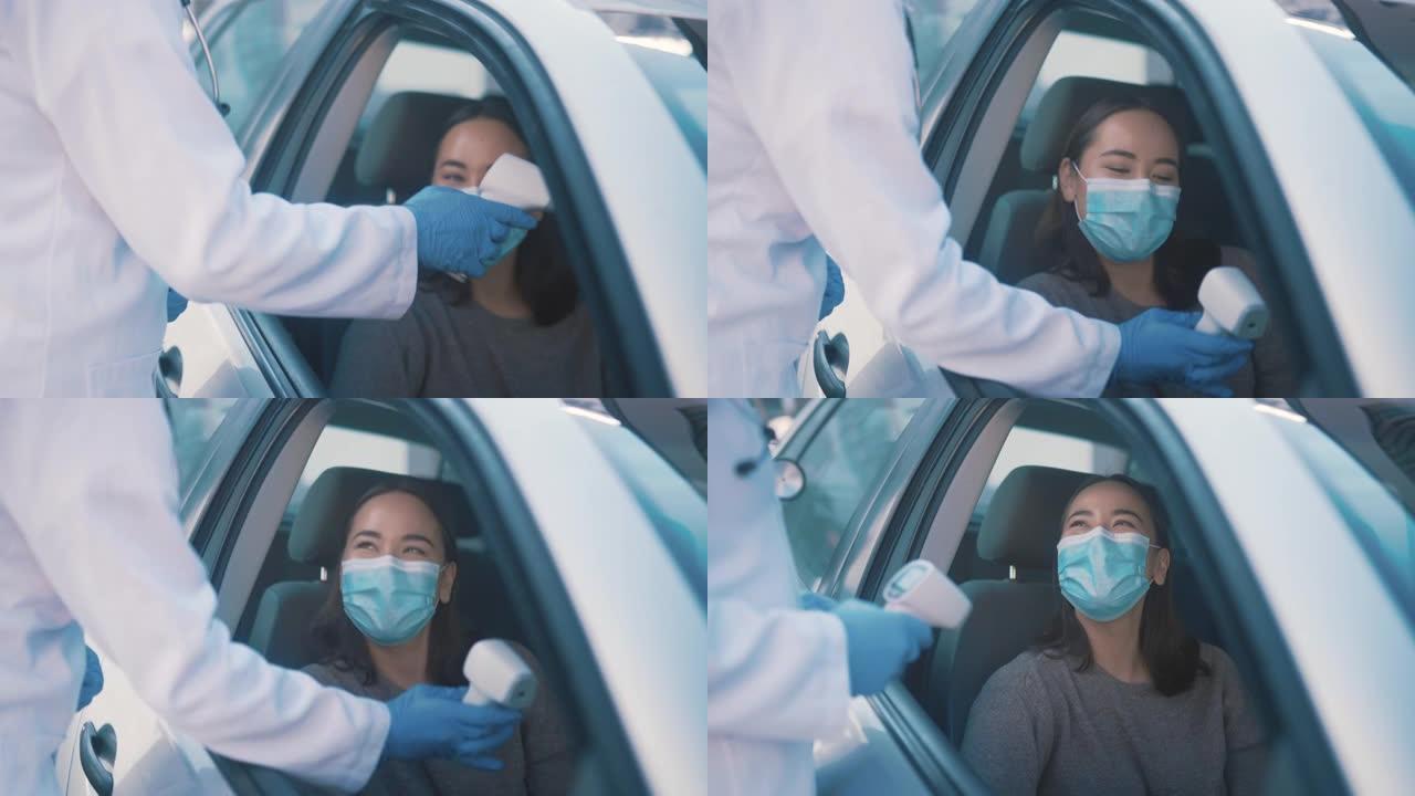 4k视频片段，一位有吸引力的年轻女护士在covid疫苗中通过室外拍摄一名妇女的体温