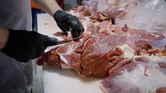 屠夫用刀割肉。切掉肉块。特写