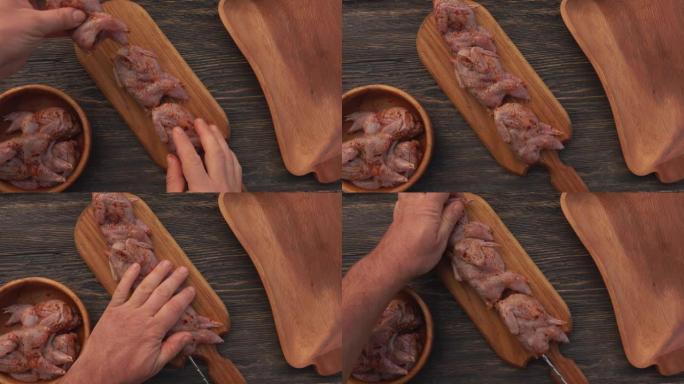 将生腌制鹌鹑放在木板上的手的俯视图