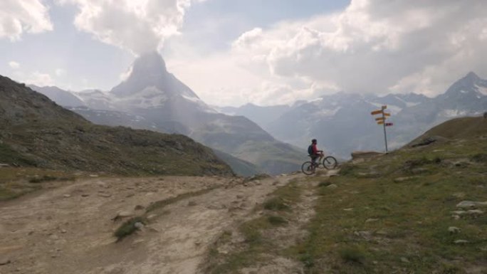 山地车沿着路牌下山。摩托车手准备在阿尔卑斯山下坡。