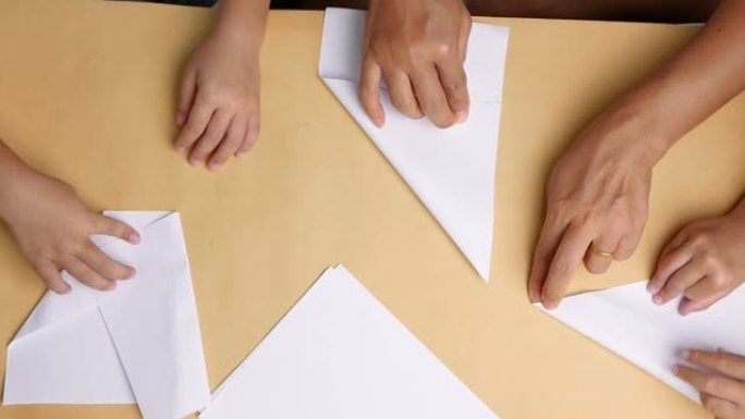 妈妈和孩子的近距离学习在家折叠日纸折纸。折纸艺术。顶视图