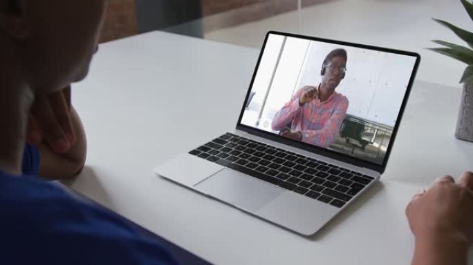 非裔美国妇女在家中与男性办公室同事在笔记本电脑上进行视频通话