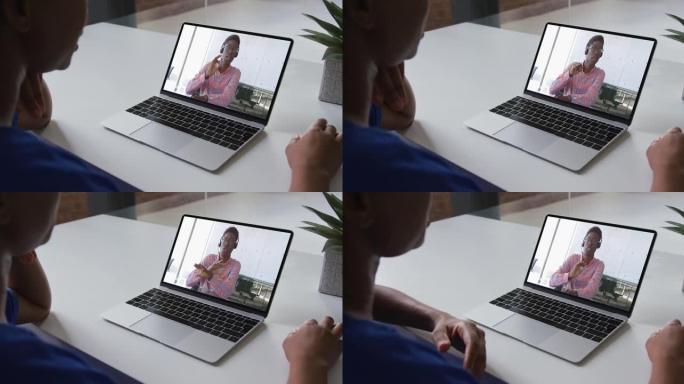 非裔美国妇女在家中与男性办公室同事在笔记本电脑上进行视频通话