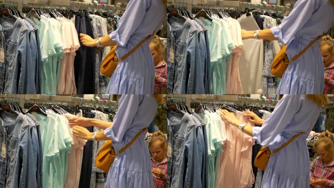 妈妈和女儿去购物服装选择一件衣服