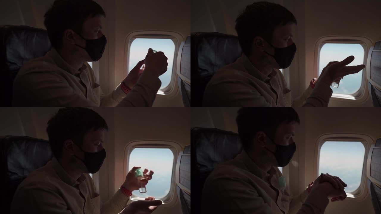 手持男子戴着面罩在飞机上使用消毒剂的镜头。带防护面罩的人使用酒精凝胶，在飞机上消毒手，新型冠状病毒肺