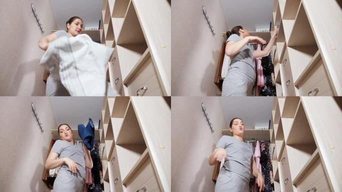 愤怒的女人从衣柜里扔掉前夫的衣服