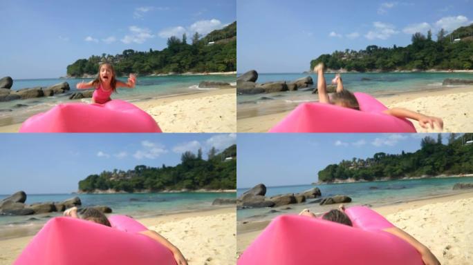 在海滩上的充气粉红色沙发上跳了一点