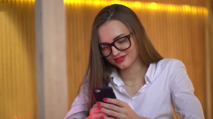 年轻的女商人在办公室写手机短信。4 k.年轻女性在社交网络中查看新闻提要，在智能手机上浏览互联网，在