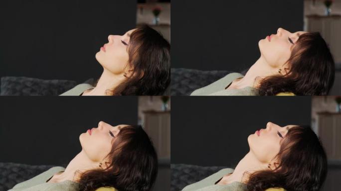 平静的女孩躺在沙发上闭上眼睛，在家休息