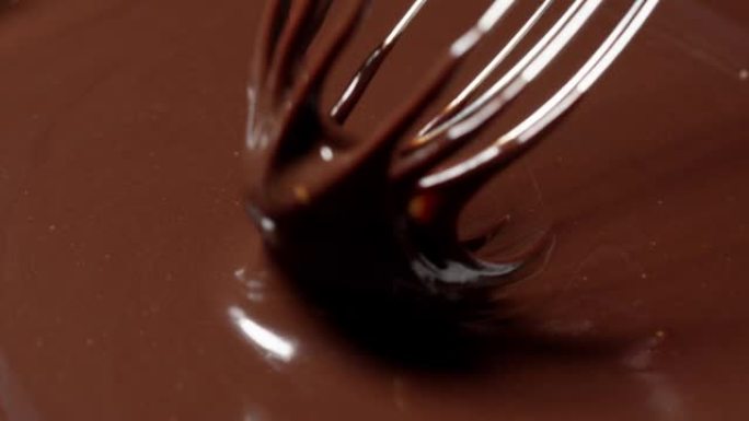 慢动作混合，用搅拌器搅拌高级黑融化的巧克力，制作糖果的过程