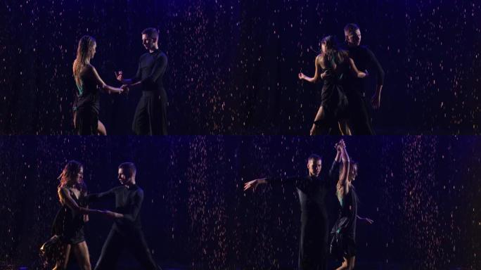 一对年轻性感的舞者在雨滴中进行了热情的bachata舞蹈。合作伙伴在黑色的工作室背景下在蓝色霓虹灯中