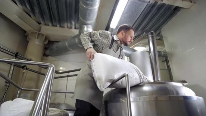啤酒厂。酿酒商在啤酒厂的大罐中混合麦芽。