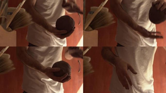 4k录像片段，一名男子在陶艺工作室里用粘土工作
