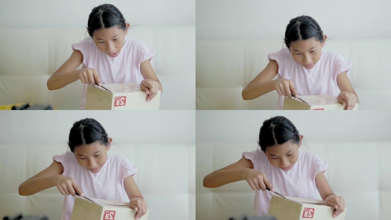 亚洲女孩坐在家里的沙发上从网上购物中拆箱商品，在新型冠状病毒肺炎中检疫生活方式概念。