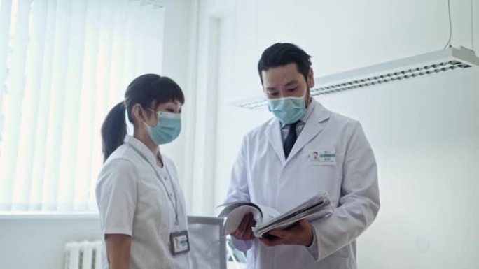 亚洲男医生女护士讨论病人病例