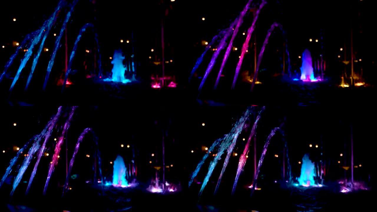 4k视频。喷泉中的喷流在夜间以不同的颜色被照亮。