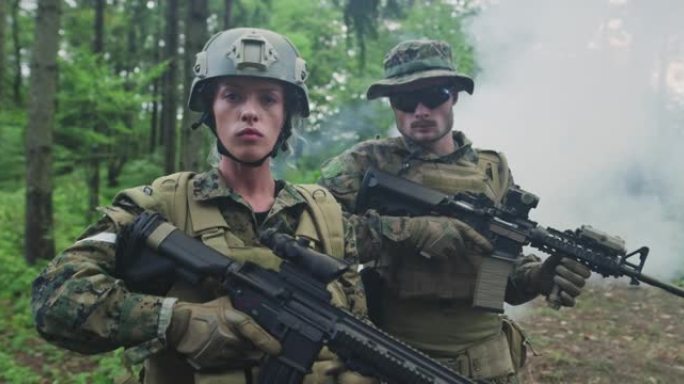 一队士兵在森林地区巡逻，队伍中有男有女士兵在浓密的森林中，烟雾缭绕