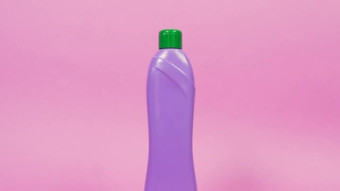 带有绿色盖子和家用化学品的紫色塑料瓶。