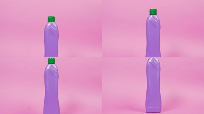 带有绿色盖子和家用化学品的紫色塑料瓶。
