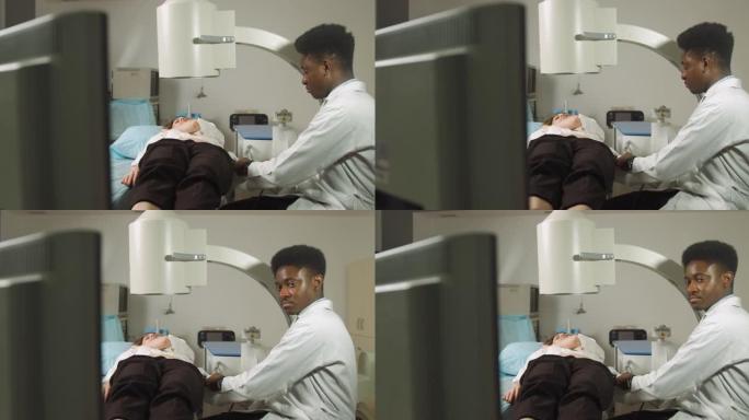 体外休克波疗法。肾结石治疗。非洲男医生的前视图看着碎石机的数字屏幕以确定女性患者的结石位置