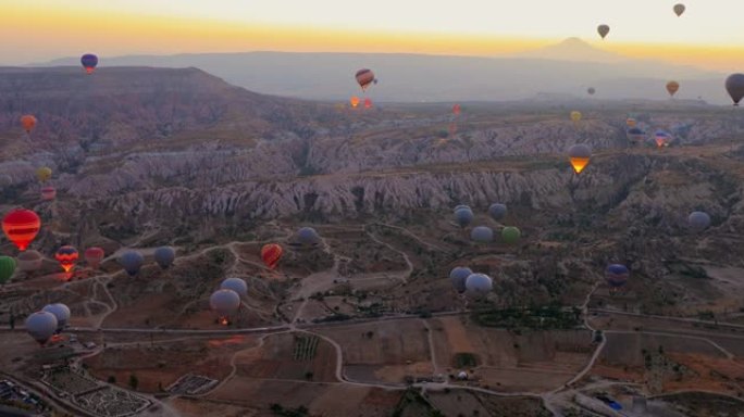 土耳其，卡帕多西亚，2021年10月12日: 鸟瞰热气球在爱情谷，格雷梅，内夫希尔，日出上空飞行的早