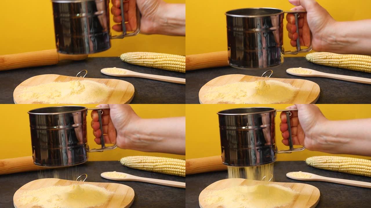 玉米生产产品的概念。厨师的手在木板上筛玉米粉，在黄色背景上筛新鲜玉米。
