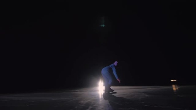 孩子在冰上速滑训练。夜间滑冰。这个女孩在冬天穿着运动服和运动眼镜滑冰。户外慢动作。