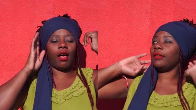 4k垂直视频，非洲妇女在红色背景上打手势和跳舞