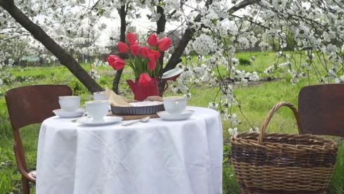 大风春日私人花园盛开的树下的餐桌