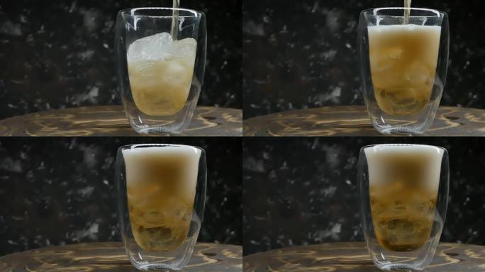 将淡水果啤酒倒入装有冰块的玻璃双层玻璃杯中。特写，慢动作，复制空间。