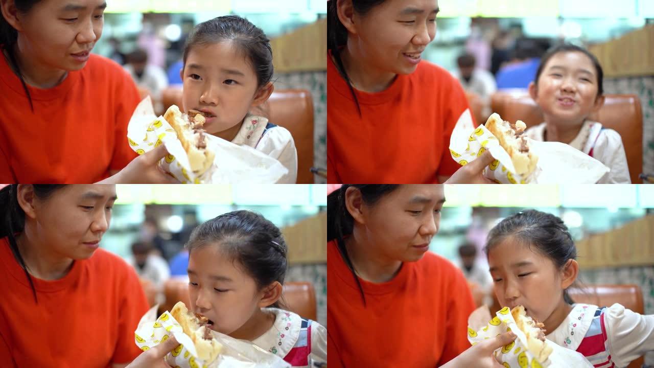 母亲给女儿喂了一个中国汉堡 (肉夹馍)