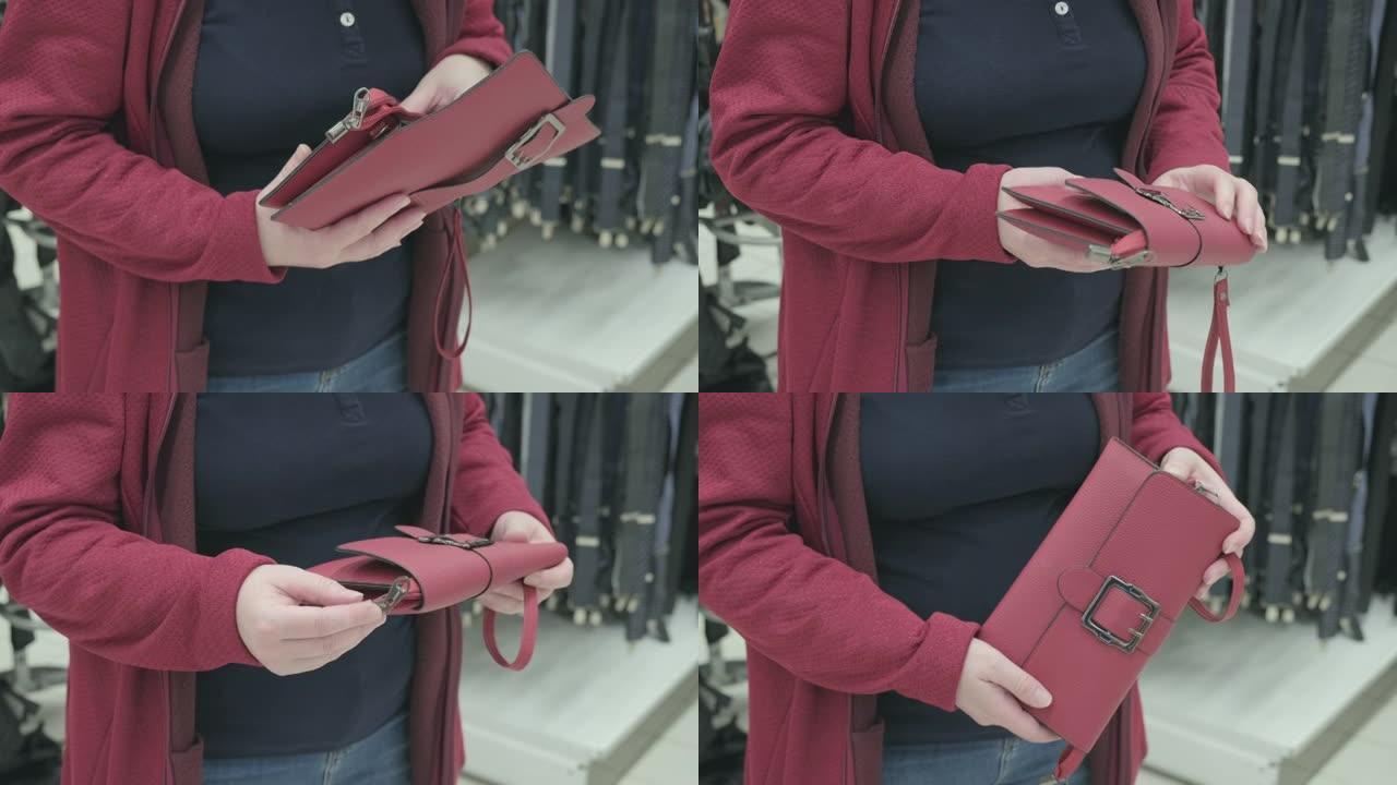 商店里的女人挑选了一个红色的手拿包进行购买。双手特写镜头