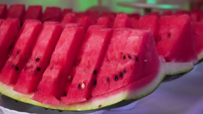 红色的夏季水果西瓜在节日的餐桌上。节日餐桌的装饰，甜品的西瓜片